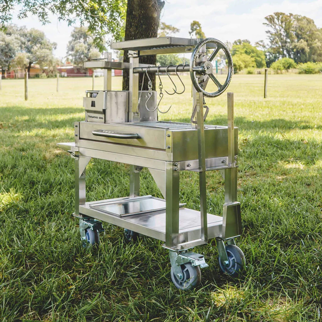 Tagwood BBQ Argentine Santa Maria Wood Fire And Charcoal Gaucho Grill BBQ03SS Mini SAK35620 - Lifestyle On Grass Corner View