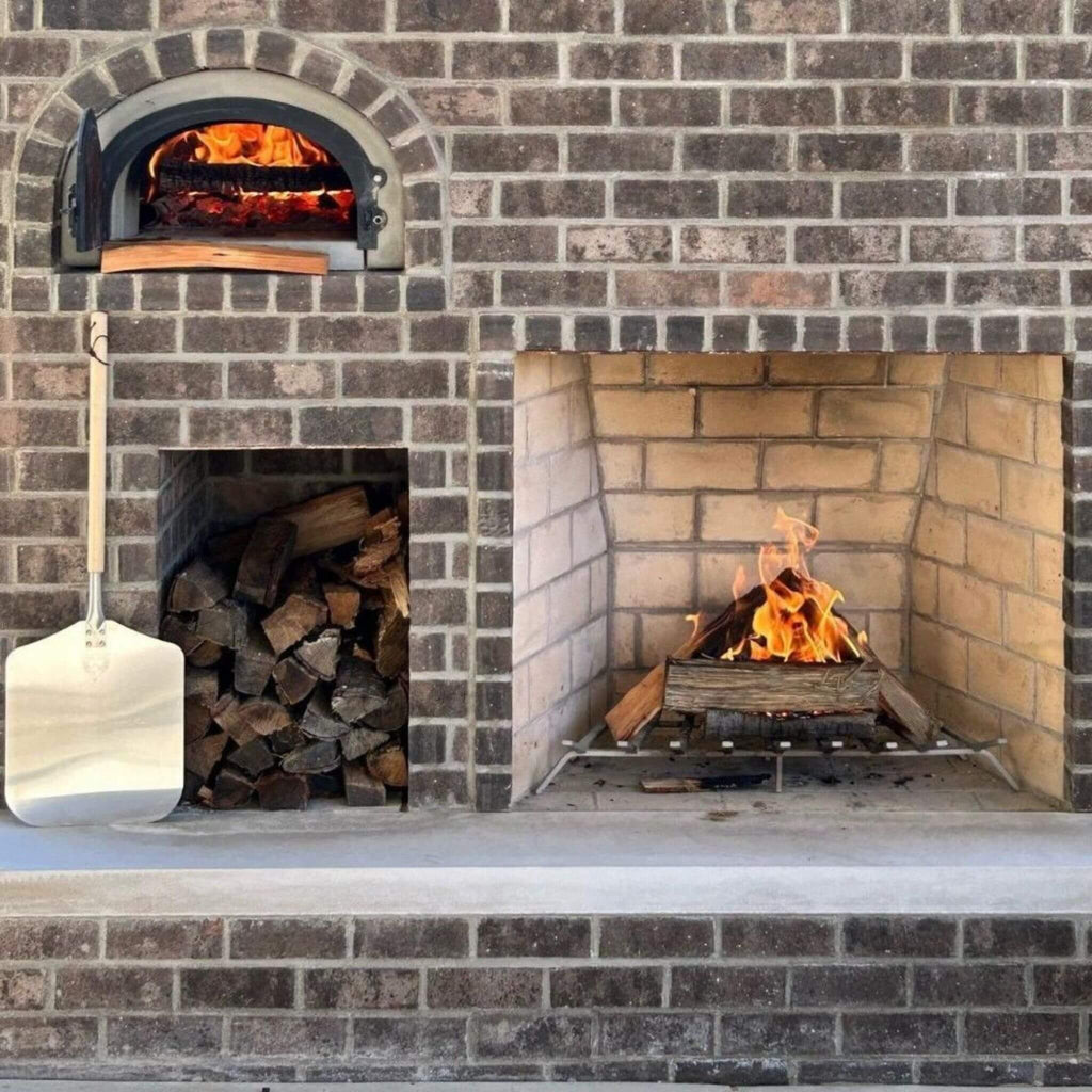 Chicago Brick Oven CBO-750 Wood Fired Pizza Oven DIY Kit With 38" x 28" Cooking Surface [CBO-O-KIT-750] (SAK51793) - Saksby Wholesale - Lifestyle Image Outside On Bricks With Wood