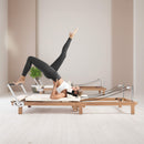 Foldable Dual Resistance Pilates Reformer With Jumpboard (SAK83914) - Saksby Wholesale - Lifestyle White Side Left View In Studio