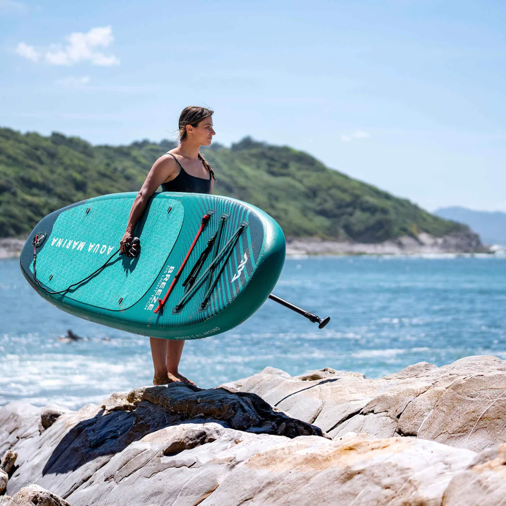 Aqua Marina Breeze 9FT Green Compact Inflatable SUP With Drop Stitch Light Technology [BT-23BRP] (SAK68745) - Saksby Wholesale - Woman Standing On Shore Side View