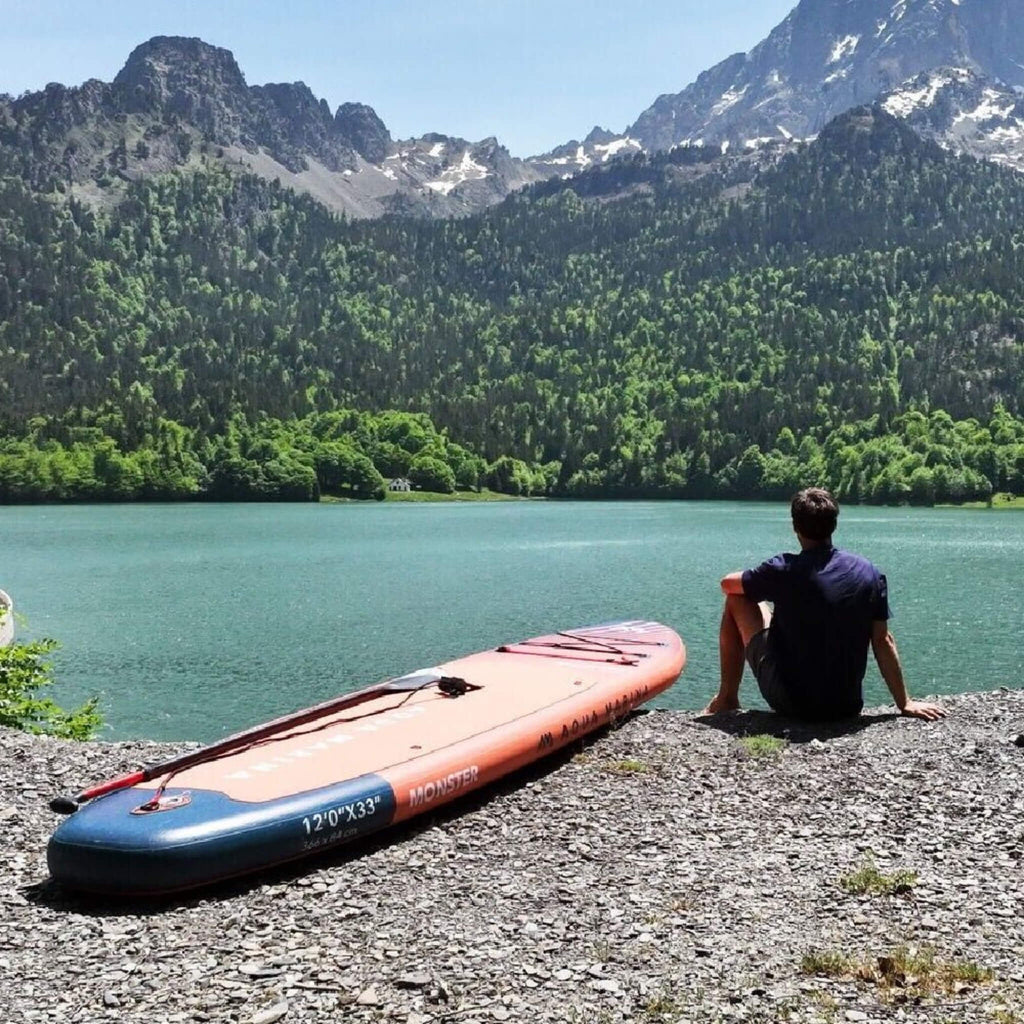 Aqua Marina Monster 12FT All-Around ISUP Sky Glider With Swift Attach Center Fin [BT-23MOP] (SAK56240) - Saksby Wholesale - Lifestyle With Man Sitting Beside In Front Of Lake